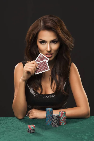 Сексуальна брюнетка з покерними картами на чорному тлі — стокове фото