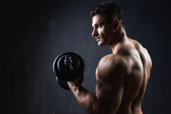 Knappe gespierde bodybuilder tonen zijn spieren. — Stockfoto