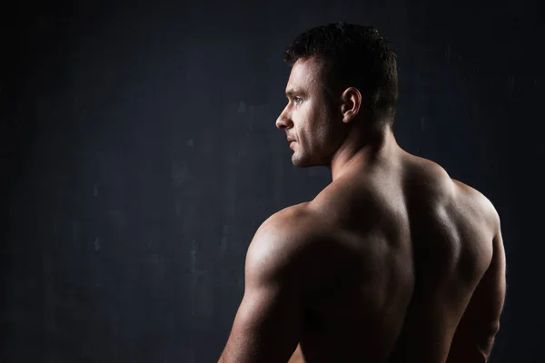 Schöner muskulöser Bodybuilder, der seine Muskeln zeigt. — Stockfoto