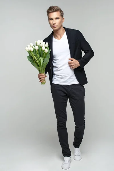 Schöner Mann mit Blumen — Stockfoto