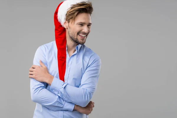 Pohledný muž nosí Santa Claus klobouk v modré košili — Stock fotografie
