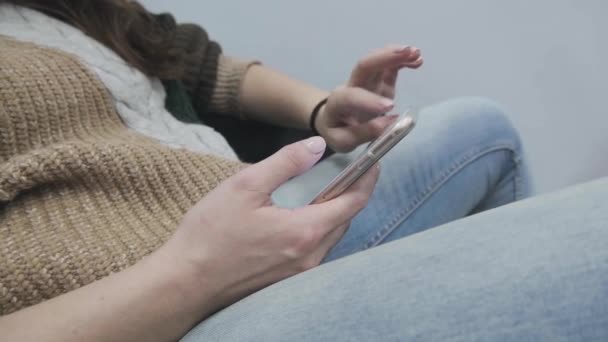 Kotlu bir kız kanepeye oturur ve dokunmatik telefon kullanır. — Stok video