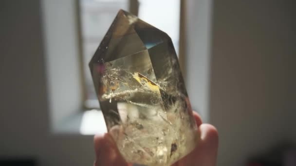 Прозрачный камень в руке при солнечном свете — стоковое видео