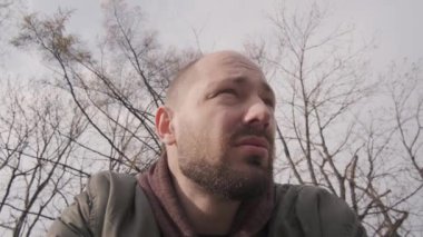 Kameraya konuşan kısa saçlı bir adamın portresi.