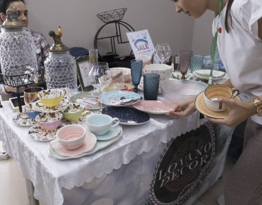 Satıcı ve alıcı, üzerinde mal olan masanın yanında.