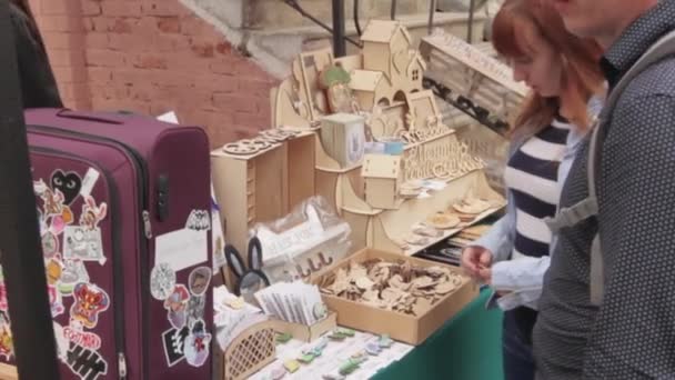 Rusia, Vladivostok, mayo 25, 2019-mercado callejero, chica elige iconos de madera — Vídeo de stock