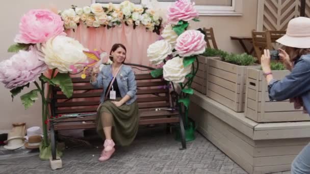 Rusya, Vladivostok, 25 Mayıs 2019. Kız poz veriyor ve arkadaşı fotoğraf çekiyor. — Stok video