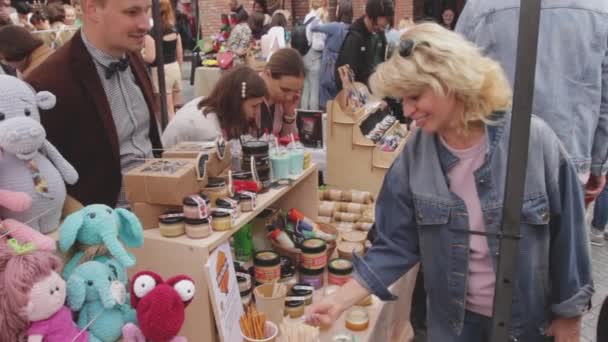 Росія, Владивосток, 25 травня 2019 року вуличний ринок, жінка, яка скуштує медові продукти — стокове відео