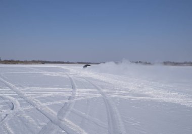 Spassk-Dalny, Primorsky Krai, Rusya-2020 Şubat 8: Karlı yolda donmuş gölde ağaçların arka planına karşı siyah araba sürüyor