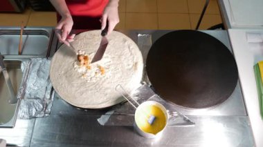 Kadın Şef mutfak profesyonel kalbur üzerinde krep sırasında fry pişirin. Krep Pan kızartma işlemi.