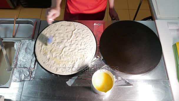 Köchin kochen einen Pfannkuchen in der Küche auf professionellem Grill beim Braten. Pfannkuchen in der Pfanne braten. — Stockvideo