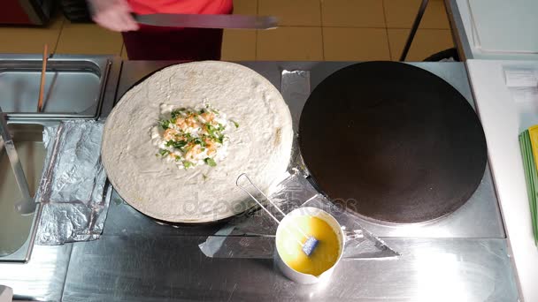 Mujer cocinero cocinar un panqueque en la cocina en plancha profesional durante freír. El proceso de freír panqueques en la sartén . — Vídeo de stock