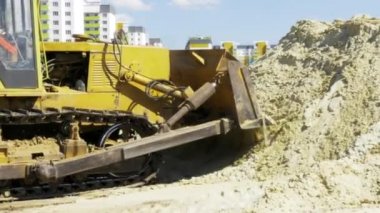 Sarı buldozer hareket. Kentin konut bir çok daire kompleksi inşaatı. İnşaat. Stok video görüntüleri.