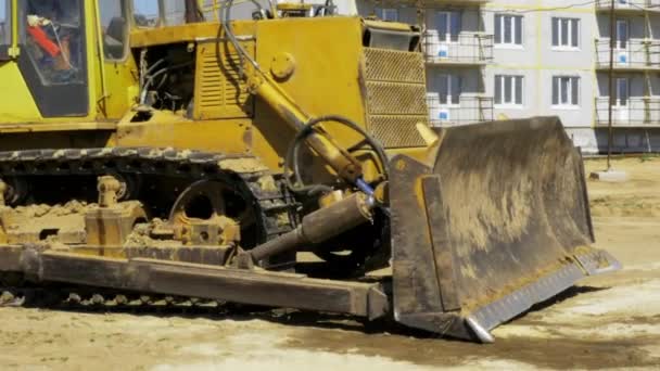 Yellow bulldozer in motion. Construction of a residential multi-apartment complex in the city. Construction. Stock video footage. — Stock Video