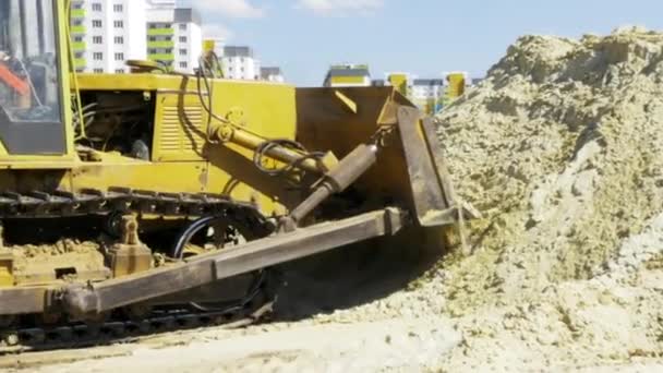 Yellow bulldozer in motion. Construction of a residential multi-apartment complex in the city. Construction. Stock video footage. — Stock Video