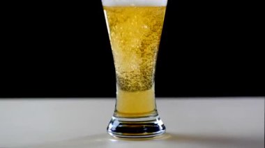 Bira bardağına siyah arka plan üzerine yağıyor. Bubbles ve köpük bira cam. Köpük bardak bira kayar. Bira cam doldurma. bira kabarcıklar. Bira cam siyah arka plan üzerine dökülür.