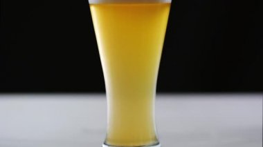 Bira bardağına siyah arka plan üzerine yağıyor. Ağır çekim