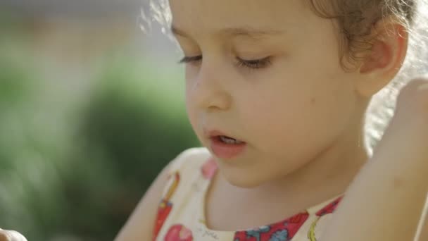 Niña comiendo helado. Una niña se come un helado. 4k . — Vídeo de stock