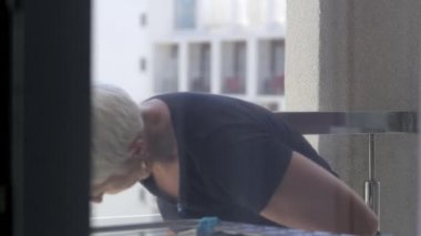 Pencere - süpürge ile eldiven, yansıması Oda ve bir bez ve deterjan toz ve kir ile balkon penceresi temizler.