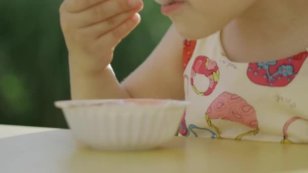 Une petite fille qui mange de la glace. Une petite fille mange une glace. 4k . — Video