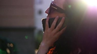 Açık havada Evet güzel bir kadın. Genç bir anne sokakta konuşuyor. Gözlüklü bir kadın. Ağır çekim.