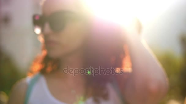 Beautiful woman talking on the phone outdoors. A woman with glasses. Slow motion. — Stock Video