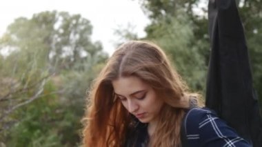 Güzel bir genç kız ormanda, bir gitar omzunda taşıyan yürür. Günbatımı Sunset