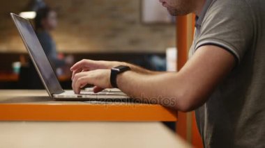 Genç işadamı kafede bilgisayar üzerinde çalışıyor. 4k.