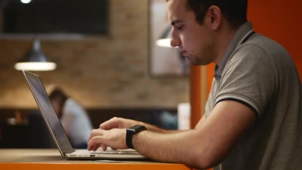 カフェ内のコンピューターに取り組んでいる青年実業家。4 k. — ストック動画