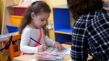 Öğretmen ve öğrenci kadının masada yı kitapla birlikte oturuyor. Öğrenci doğru öğretmenler soru cevapları ve Şükran alır.