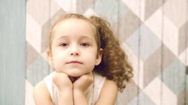 Kız bebek düşünceli bir yana, yana doğru gözleri ile bakarak görünüyor. Çocuk, çocuk, duygular.