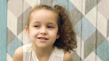 Kız bebek düşünceli bir yana, yana doğru gözleri ile bakarak görünüyor. Çocuk, çocuk, duygular.