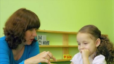 Dersleri okuyan bir kız güzel bebek kız öğretmen ile birlikte onun okul mu, konuşma ve parlak renkli küpleri kullanarak harfleri ve hayvan hareketliliği geliştirir. 4k.