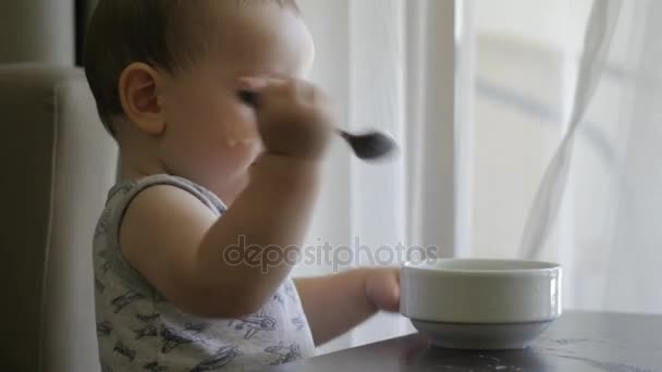 Ένα μικρό αγόρι τρώει κουάκερ τον εαυτό του. 4k. — Αρχείο Βίντεο