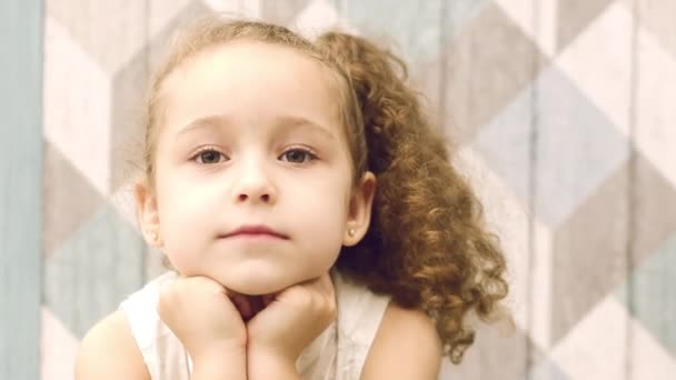 La niña se ve pensativamente a un lado, mirando de lado con los ojos. Niño, niños, emociones . — Vídeo de stock