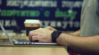 Genç işadamı caffe, dolly atış alanındaki bilgisayarda çalışıyor. 4k.