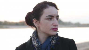 Genç kadın kameraya bakıyor ve gülümsüyor.