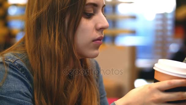 Morgonkaffe - en ung kvinna tycker att lukta och smutta på en kopp kaffe — Stockvideo