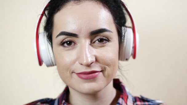 Kvinna skönhet lyssnar på musik med hörlurar och tittar på kameran wink — Stockvideo