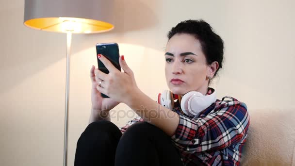 Όμορφη νεαρή γυναίκα Καυκάσιος χρησιμοποιώντας μια εφαρμογή σε ένα smartphone και γραπτών μηνυμάτων στο κινητό τηλέφωνο. — Αρχείο Βίντεο