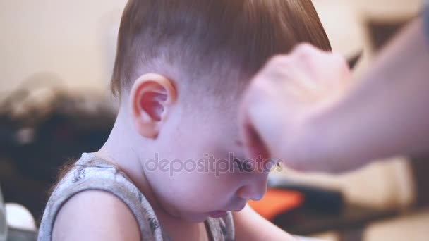 Coiffure d'enfant. Coiffeur travaillant avec un petit garçon dans un salon de coiffure. Styliste peignage enfant cheveux. Un homme qui fait une coupe de cheveux pour petit garçon. Une coupe de cheveux d'enfant. Enfants coupe de cheveux — Video