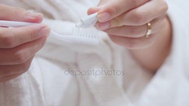 Güzel esmer diş macunu diş fırçası Tarih olarak yayılır. Genç kadın onun diş fırçalama.