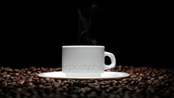 Kopp kaffe på svart bakgrund. Kaffe på bordet med stekta bönor. 4k — Stockvideo