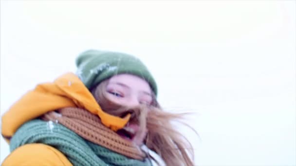 Jong koppel bedrijf handen mooi tiener meisje met blond haar, genieten van winterdag outdoorst, meisje met een groene en bruine sjaal in een groene hipster hoed, buiten wandelen, kijken naar de camera — Stockvideo