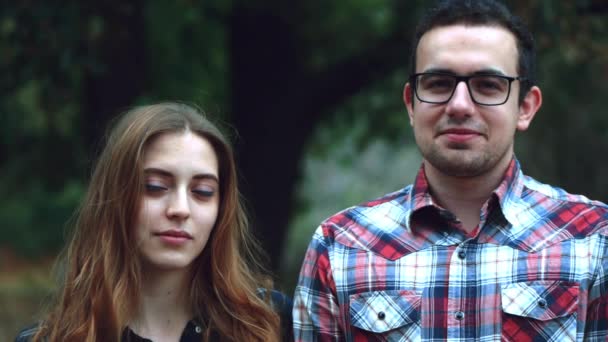 Kinograf - Płynna pętla. Szczęśliwa Młoda para hipster, spojrzenie na aparat i o siebie nawzajem podczas Letnich spacer w parku. 4k — Wideo stockowe