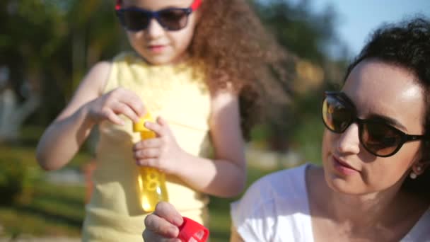 Felice sorridente Famiglia, mamma e figlia stanno giocando, soffiando bolle di sapone in estate all'aperto. Filmati delle scorte . — Video Stock