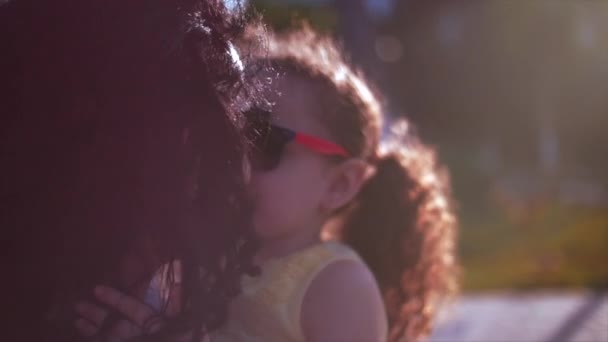 Tochter in den Armen der Mutter auf der Straße und umarmt sie herzlich und küsst sie auf die Nase. Zeitlupe — Stockvideo