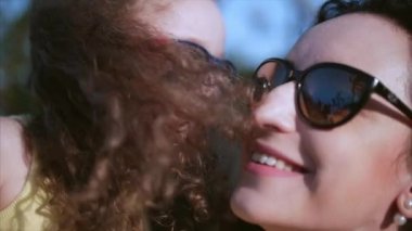 Kızı sokakta annesinin kollarında ve onu kocaman bir kucak, öpüşme ve kamera, göz gülümseyen verir yakın çekim. Ağır çekim.