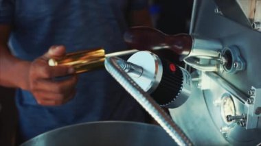 Profesyonel coffeemachine ve çiğ kahve çekirdekleri. Beyaz kahve çekirdekleri içinde kahvenin gerçek kahve yapmak için profesyonel bir makine yanmış. Ağır çekim.
