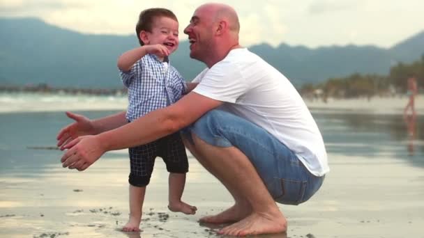 Genç aile, baba ve oğul, mutlu bir oğul babasını sahilde sarılmak. Mutlu aile, sahil yürüyüş. — Stok video